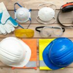 Work safety protection equipment on wooden background.